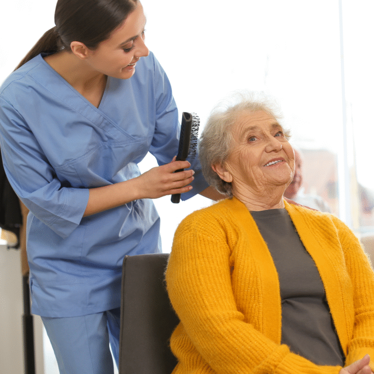 A caregiver brushing the hair of an older woman wearing a yellow cardigan.