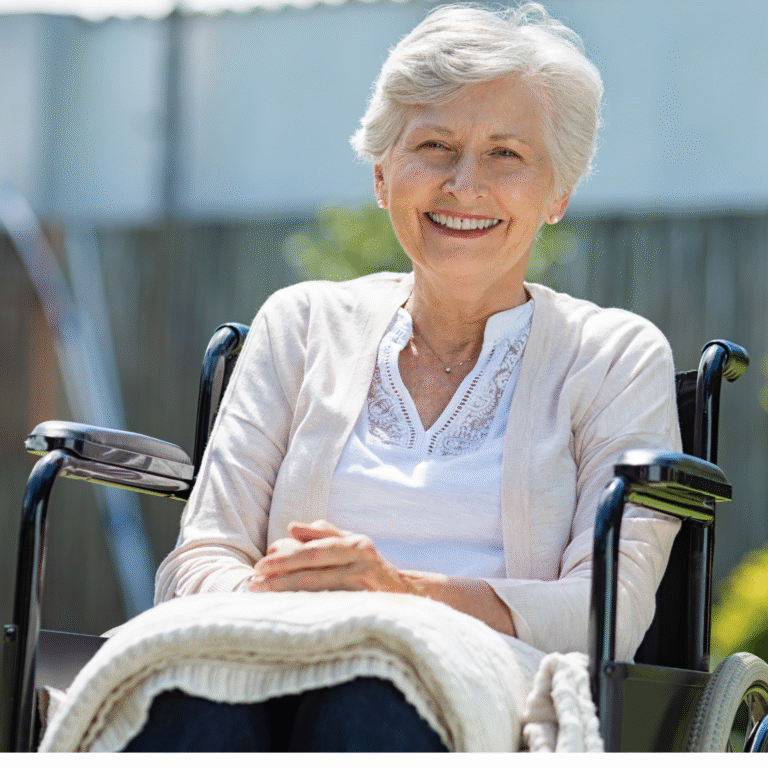 An older woman seated in a wheelchair with a blanket across her lap.
