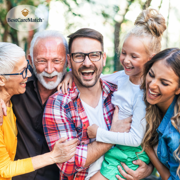 A group of older and younger adults smiling together outdoors.
