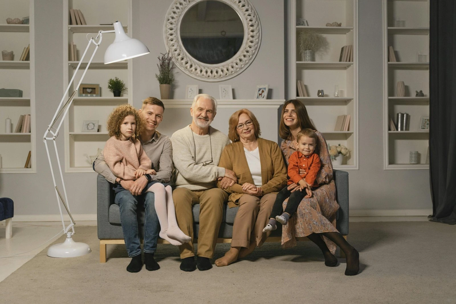 Several generations of a family sit together in a comfortable living room. BestCareMatch editorial photo.