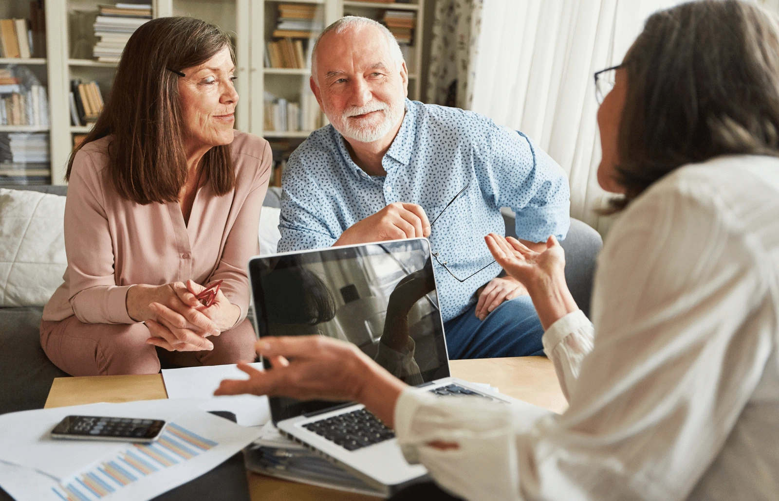An older couple talks with an advisor across a table. BestCareMatch editorial photo.